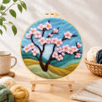 Finished pink cherry tree on hills needle felting displayed on a wooden easel