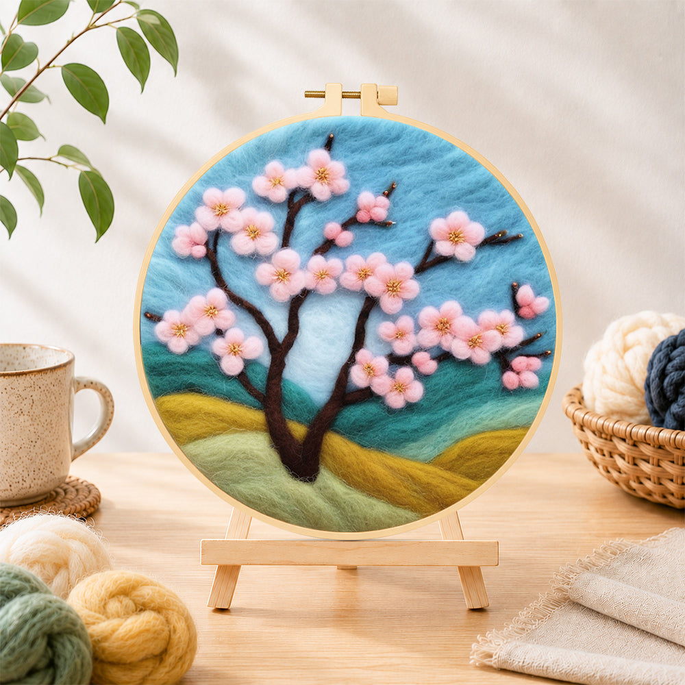 Finished pink cherry tree on hills needle felting displayed on a wooden easel
