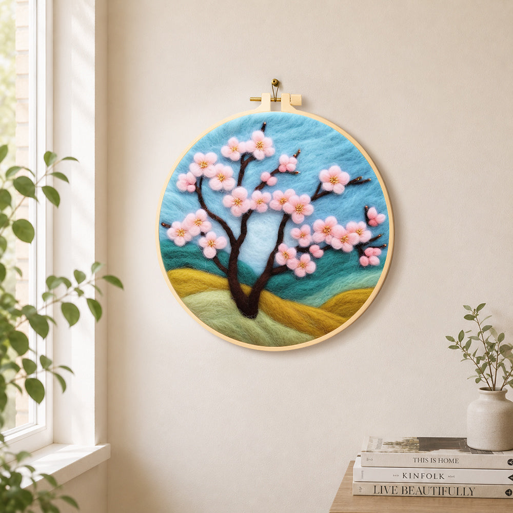 Pink cherry tree on hills needle felt wall art displayed in a bright home interior