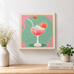 Finished pink cocktail with grapefruit artwork displayed on a wall
