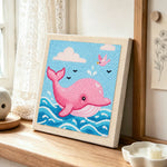 Pink dolphin jumping from waves punch needle artwork displayed on a table
