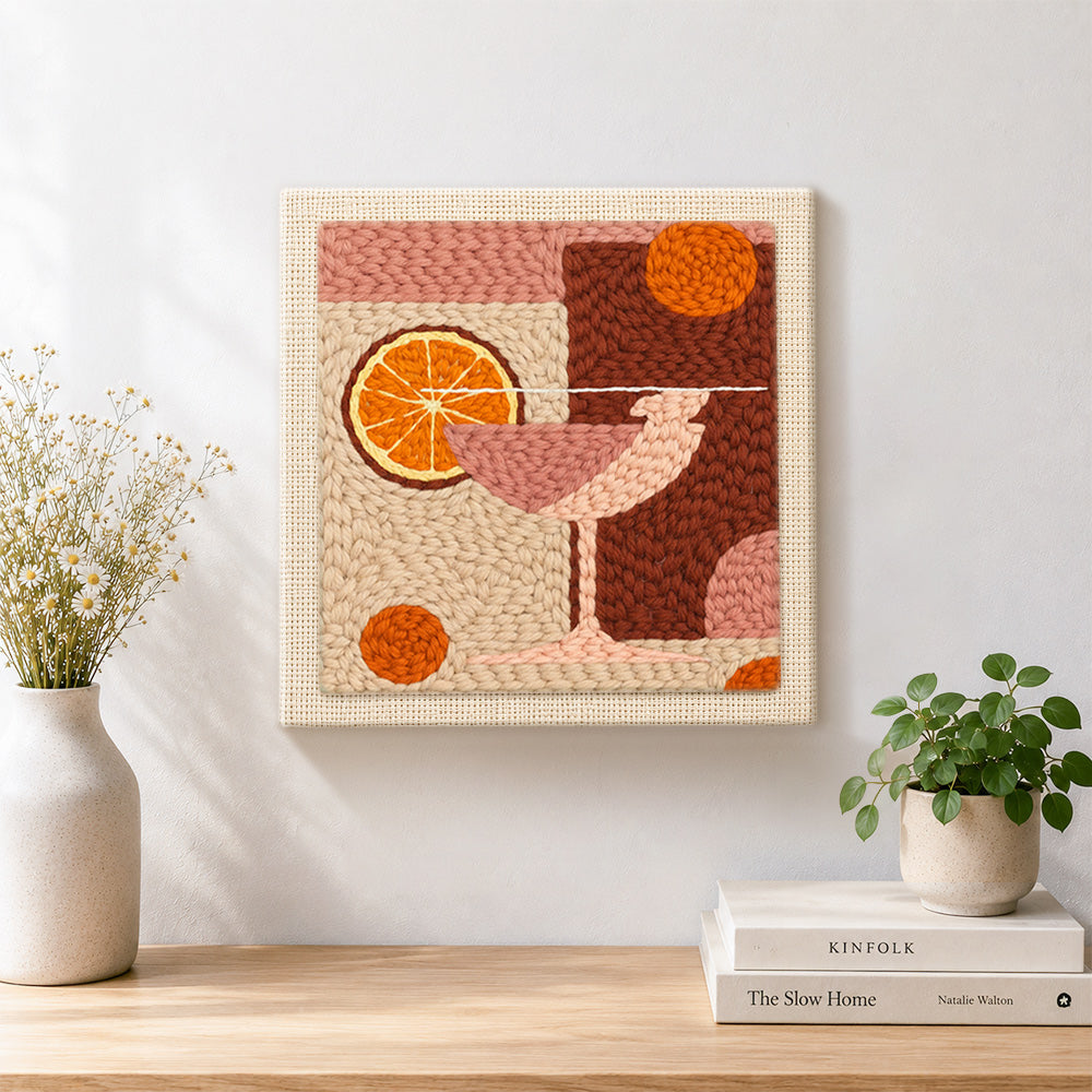 Finished pink drink with large orange slice artwork displayed on a wall