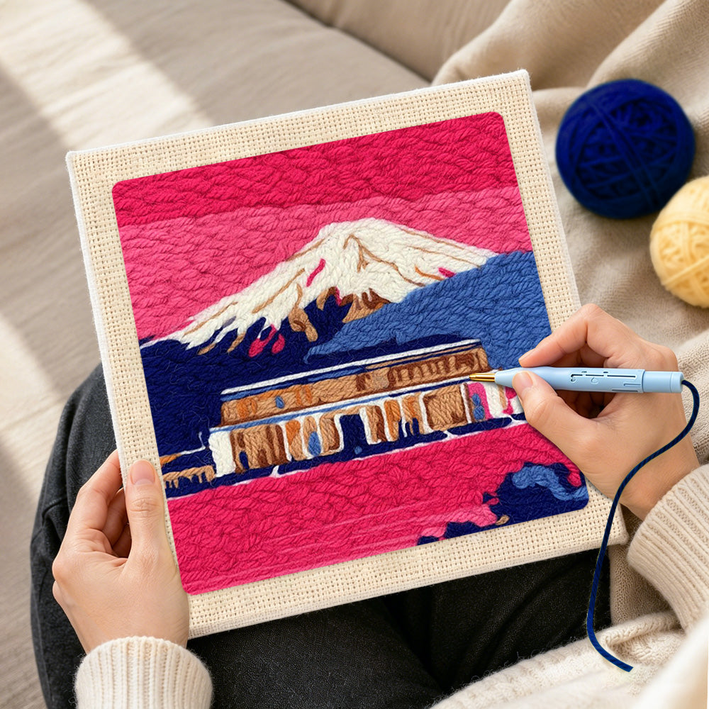 Creating handmade pink dusk temple and snowy mountain punch needle artwork