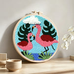 Pink flamingo couple punch needle artwork displayed on a table