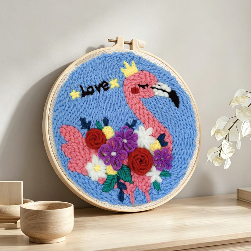 Pink flamingo with colourful flowers punch needle artwork displayed on a table