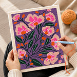 Creating handmade pink florals on deep purple background punch needle artwork