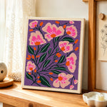 Pink florals on deep purple background punch needle artwork displayed on a table