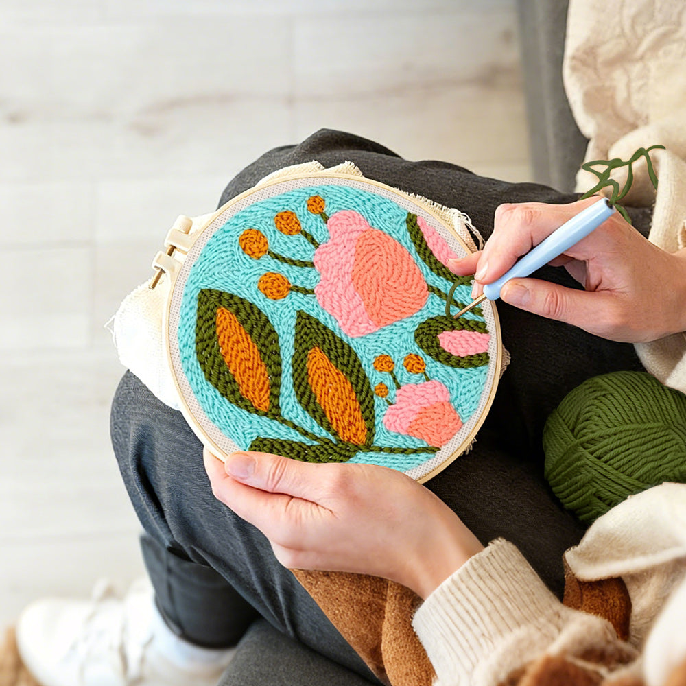 Creating handmade pink flower and green leaves punch needle artwork