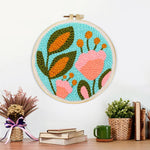 Finished pink flower and green leaves artwork displayed on a wall