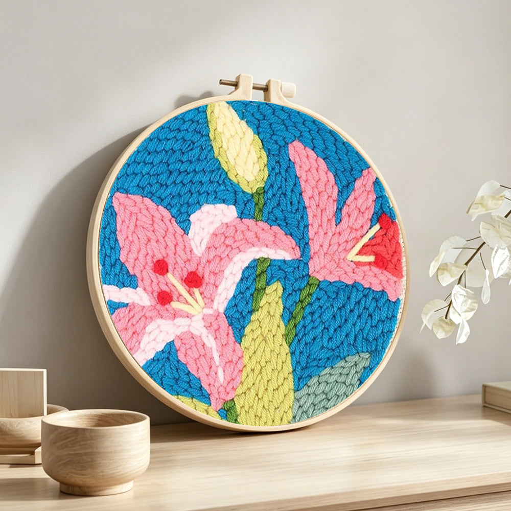 Pink lilies punch needle artwork displayed on a table