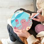 Creating handmade pink octopus punch needle artwork
