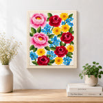 Finished pink peonies, red roses and blue forget-me-nots artwork displayed on a wall