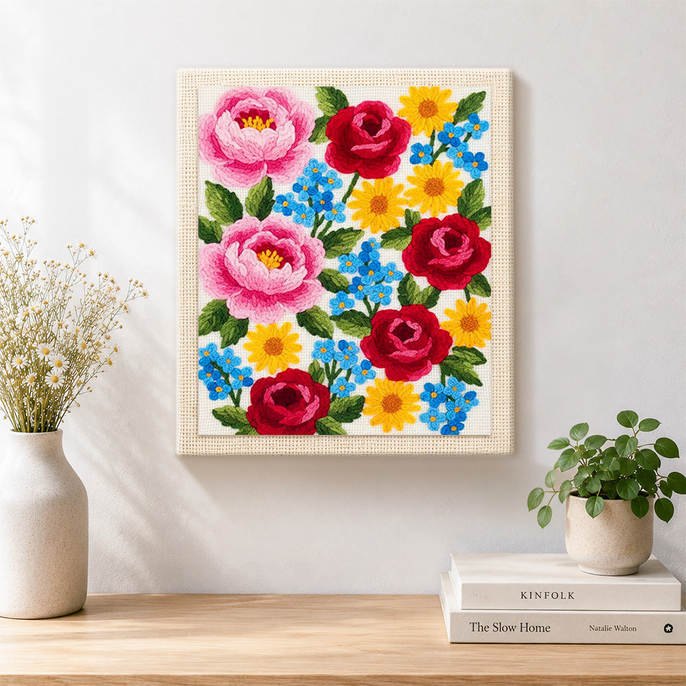 Finished pink peonies, red roses and blue forget-me-nots artwork displayed on a wall