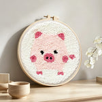 Pink piglet punch needle artwork displayed on a table