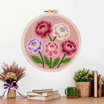 Finished pink, purple and white layered flowers artwork displayed on a wall