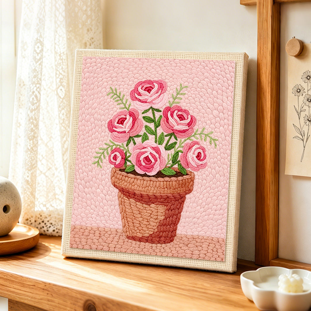 Pink roses in pot punch needle artwork displayed on a table