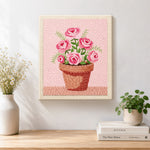 Finished pink roses in pot artwork displayed on a wall