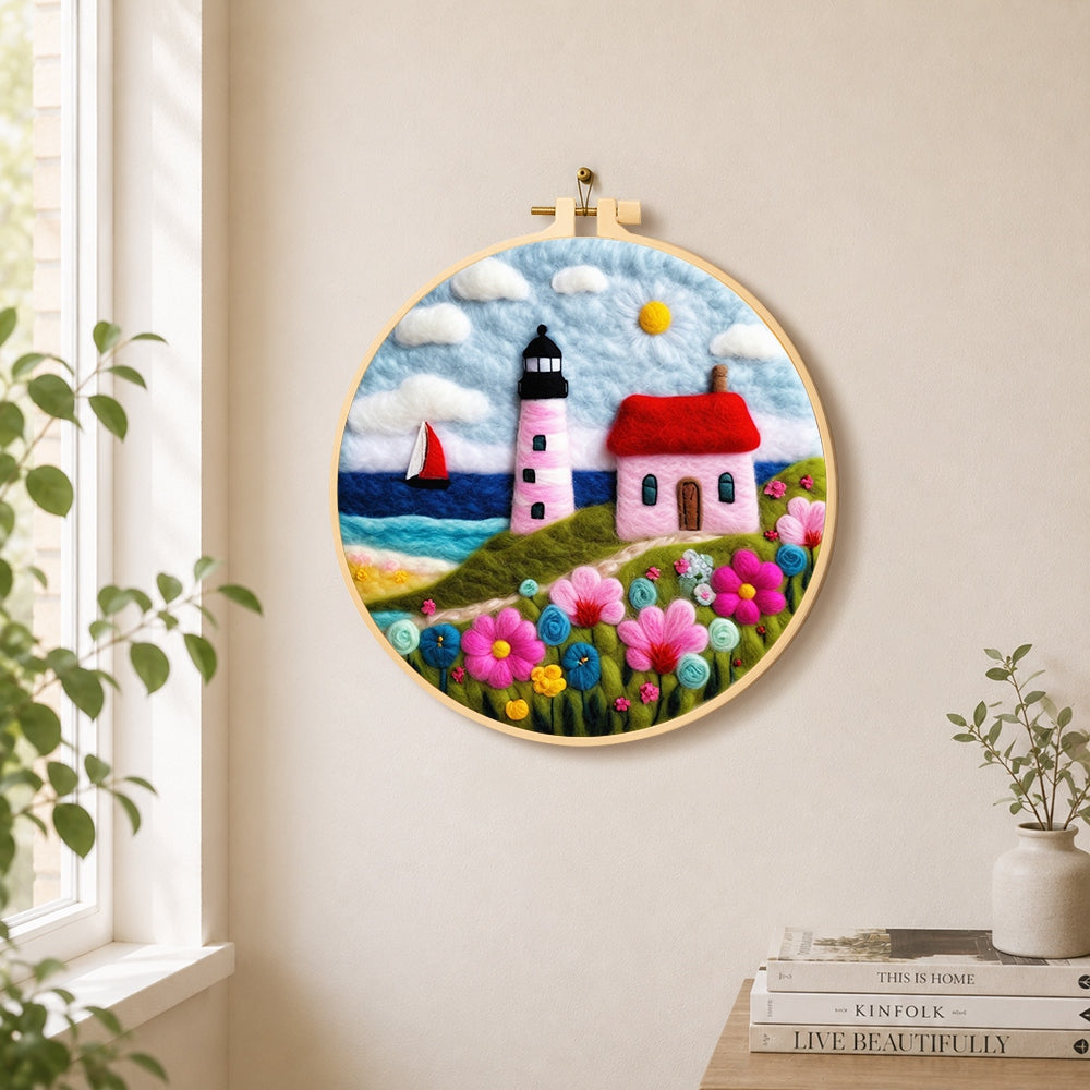 Pink striped lighthouse and flowers needle felt wall art displayed in a bright home interior