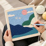 Creating handmade pink sun and green hills punch needle artwork
