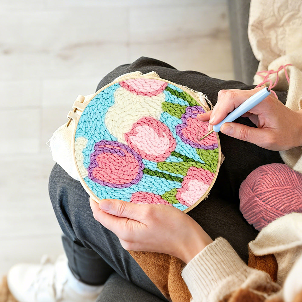 Creating handmade pink tulips under the sky and clouds punch needle artwork