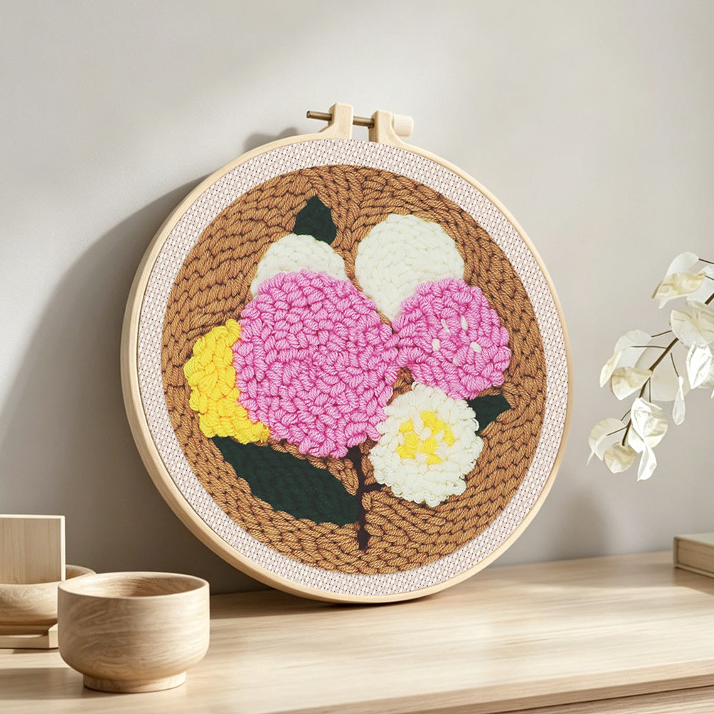 Pink, yellow and white balloon cluster punch needle artwork displayed on a table