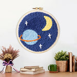 Finished planet, crescent moon and stars artwork displayed on a wall