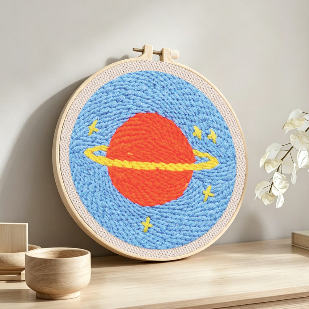 Planet with rings and stars punch needle artwork displayed on a table