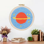 Finished planet with rings and stars artwork displayed on a wall
