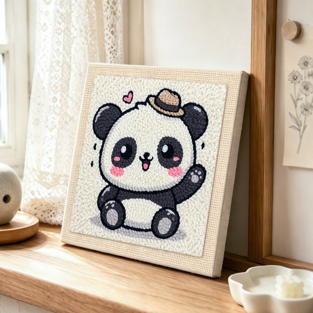 Playful waving panda punch needle artwork displayed on a table