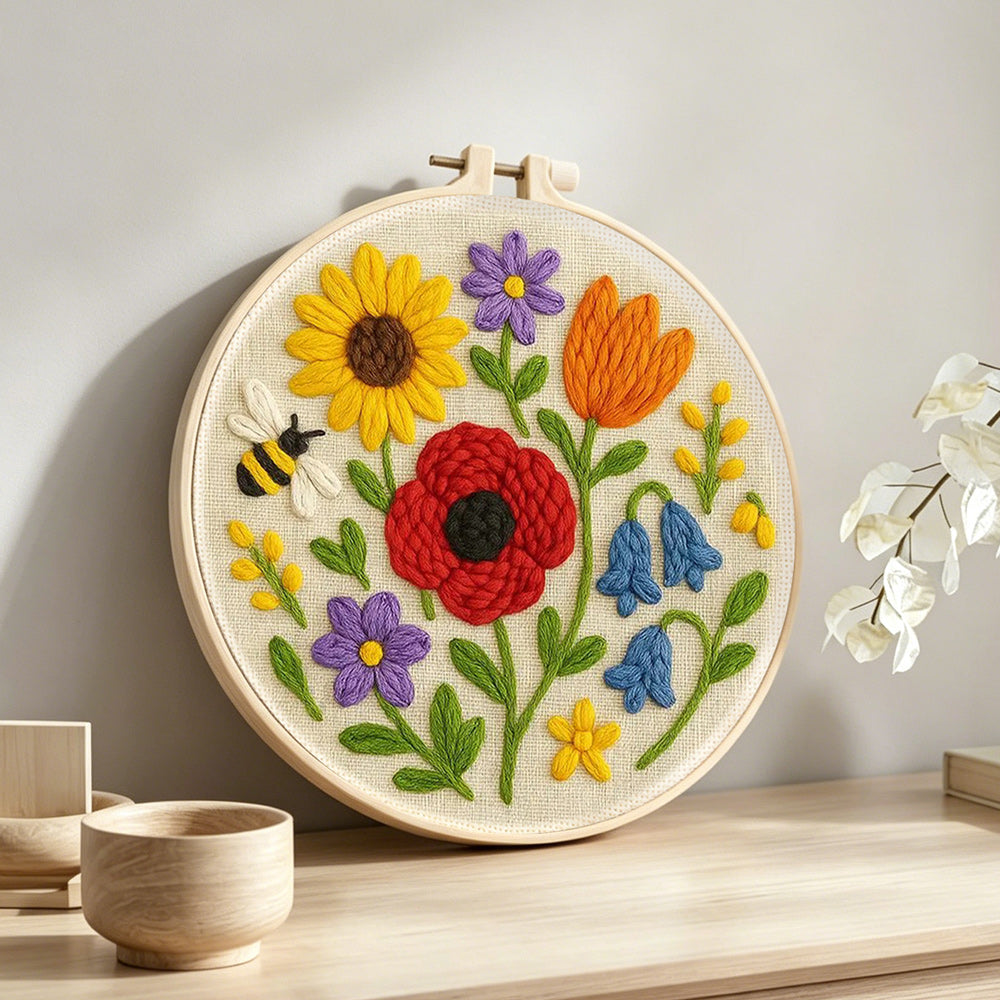 Poppy, sunflower and bumblebee punch needle artwork displayed on a table