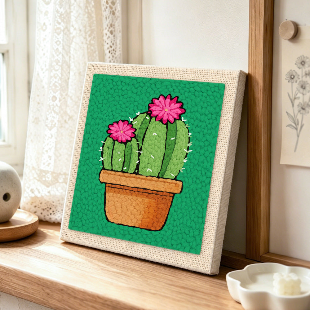 Potted cactus with pink flowers punch needle artwork displayed on a table