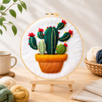 Finished potted cactus with red flowers needle felting displayed on a wooden easel