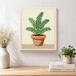 Finished potted green fern artwork displayed on a wall