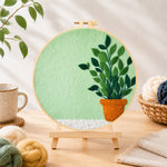 Finished potted plant on mint green needle felting displayed on a wooden easel