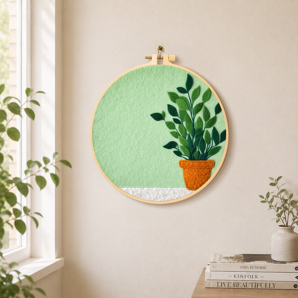 Potted plant on mint green needle felt wall art displayed in a bright home interior
