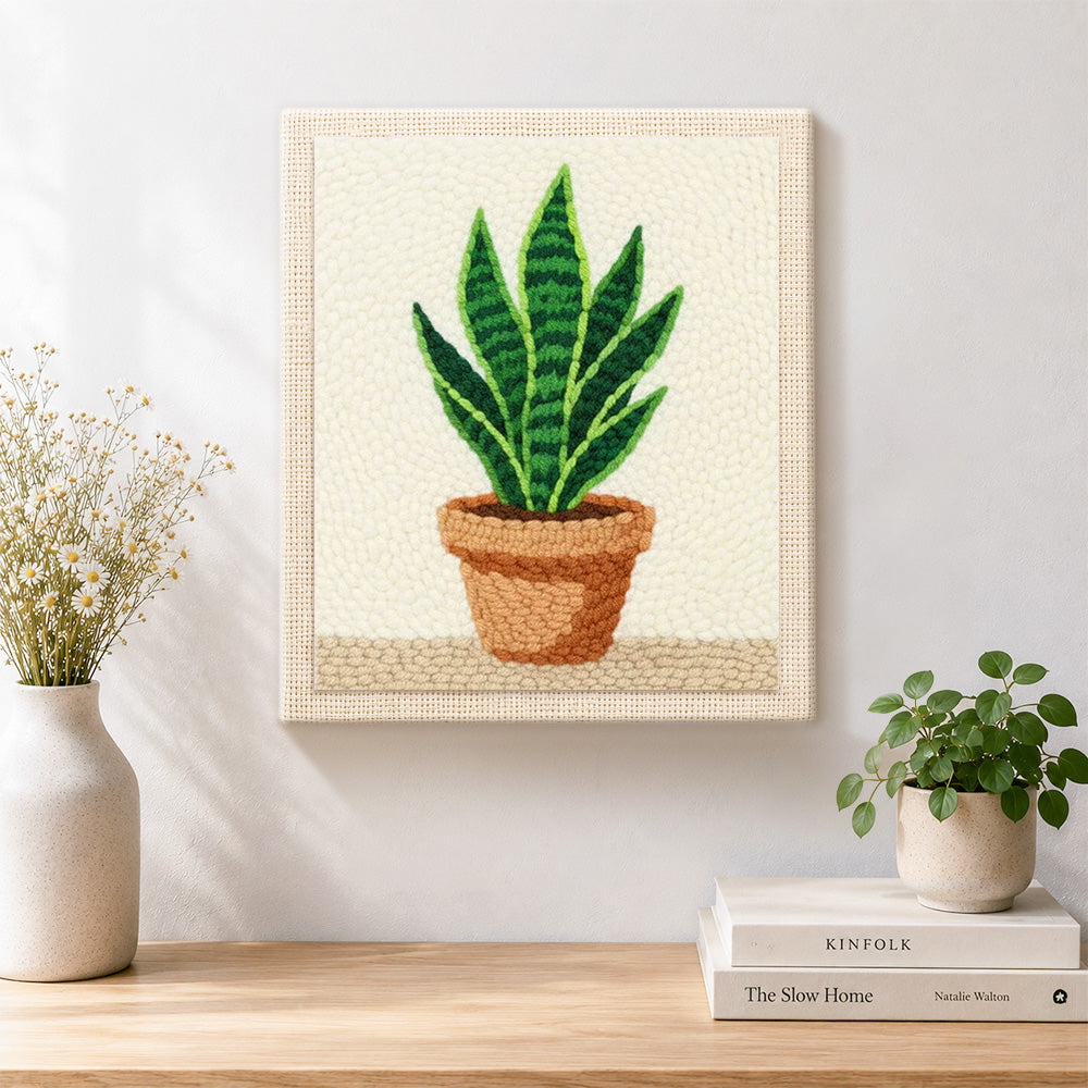 Finished potted snake plant artwork displayed on a wall