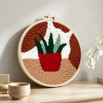 Potted succulent punch needle artwork displayed on a table