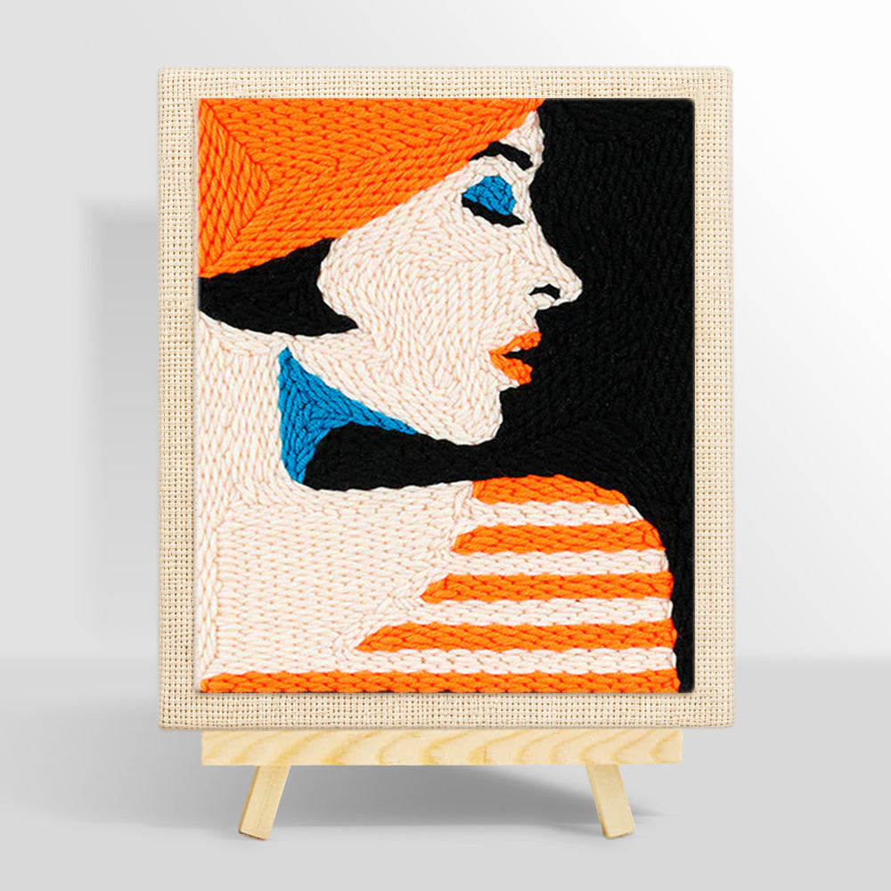 Profile of woman in orange hat punch needle kit for beginners