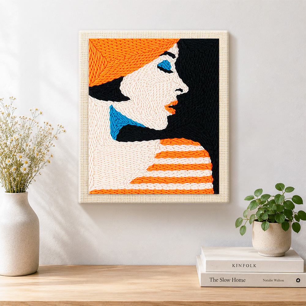 Finished profile of woman in orange hat artwork displayed on a wall