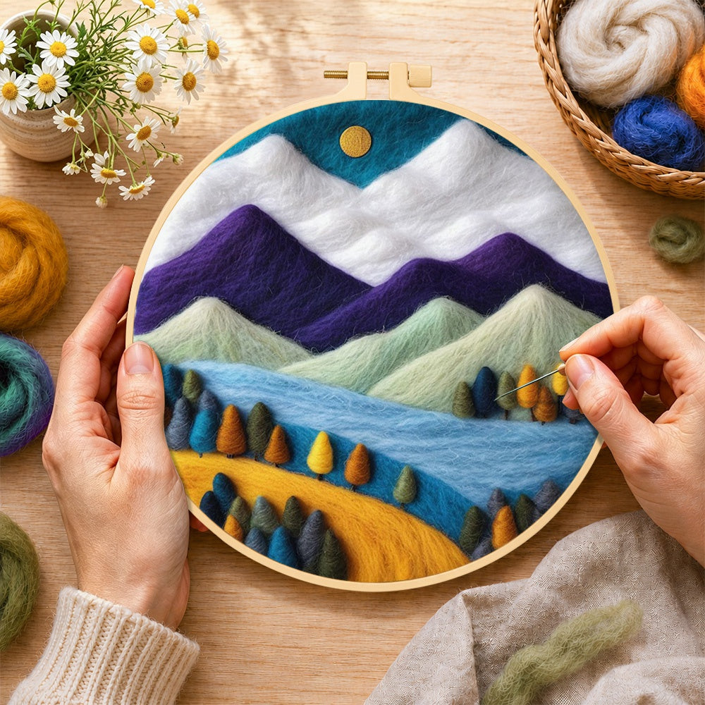 Creating the purple and white mountains with vibrant trees wool painting by hand with a felting needle