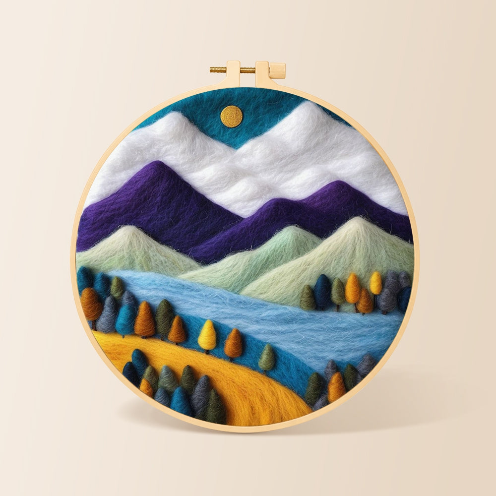 Purple and white mountains with vibrant trees needle felting kit for beginners with a round wooden frame