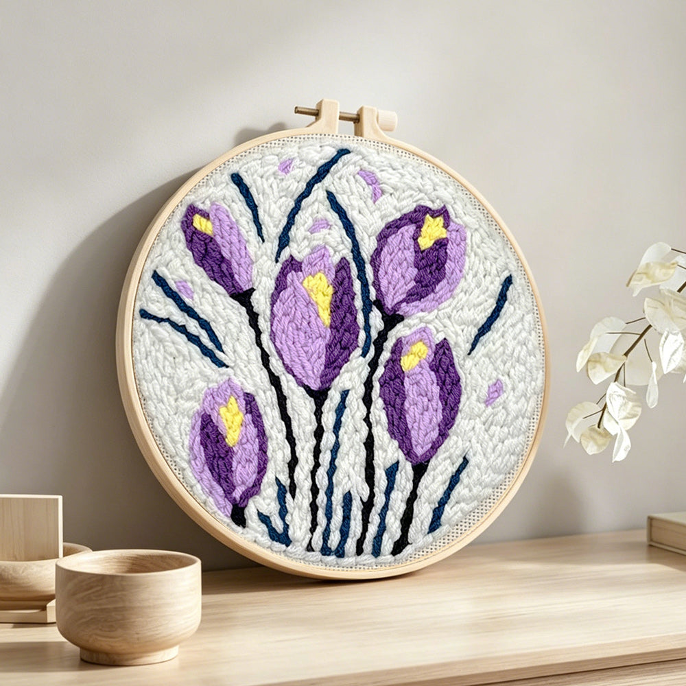 Purple and yellow tulip blooms punch needle artwork displayed on a table