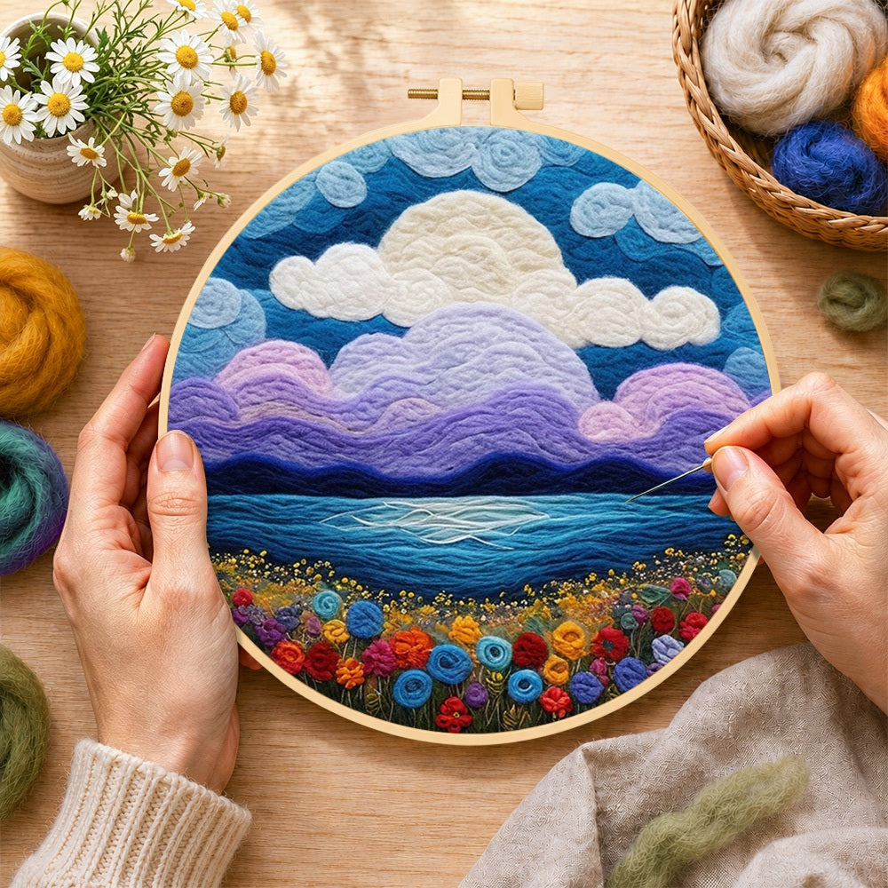 Creating the purple clouds and flower-covered coastline wool painting by hand with a felting needle