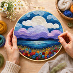 Creating the purple clouds and flower-covered coastline wool painting by hand with a felting needle