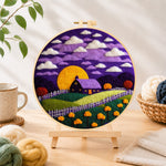 Finished purple cottage and golden moon needle felting displayed on a wooden easel