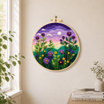 Purple dusk sky and tall wildflowers needle felt wall art displayed in a bright home interior