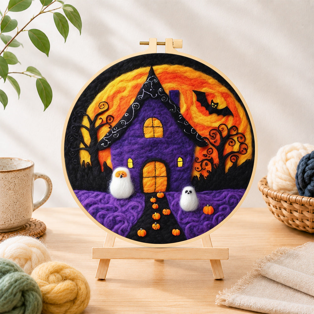 Finished purple haunted house with little ghosts needle felting displayed on a wooden easel