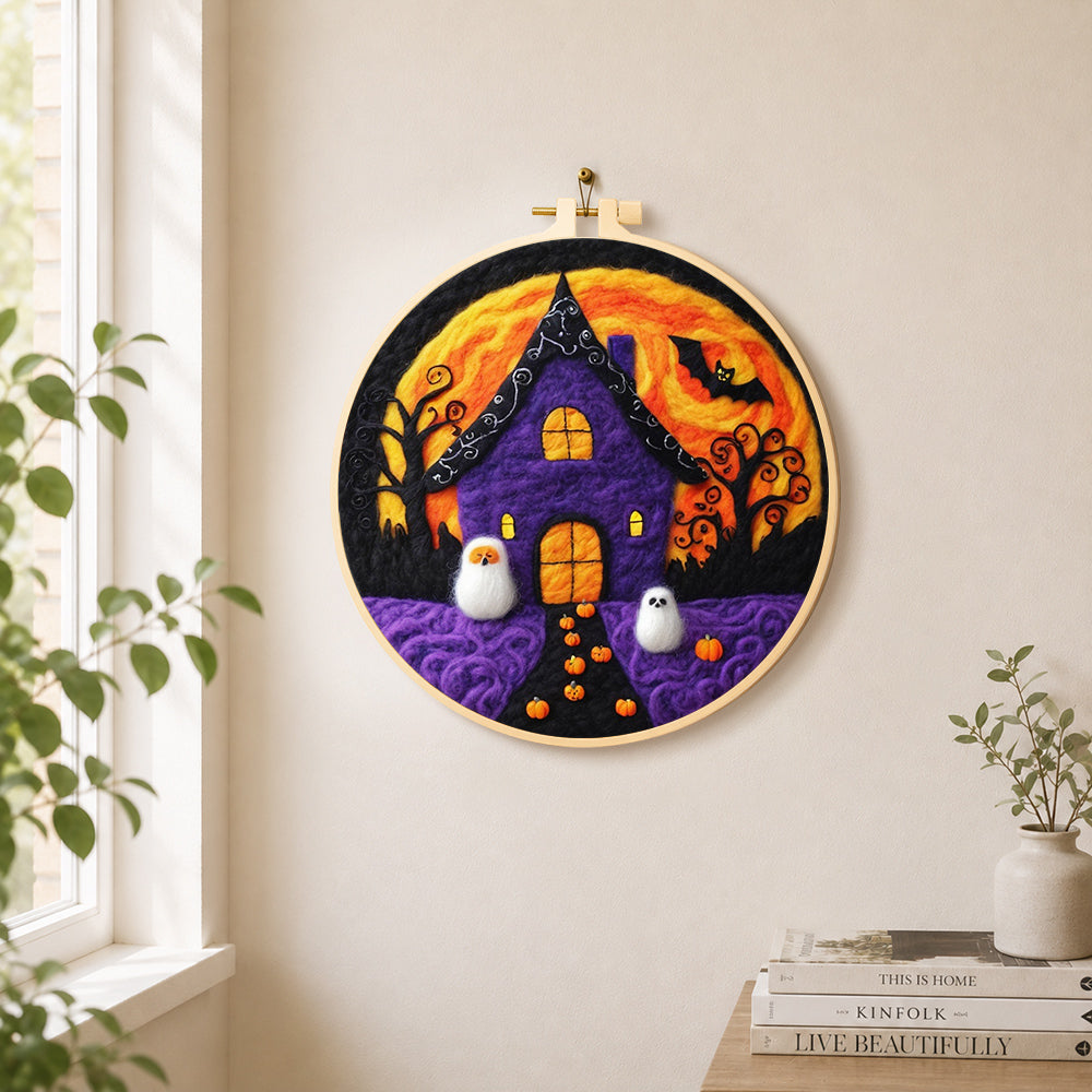 Purple haunted house with little ghosts needle felt wall art displayed in a bright home interior