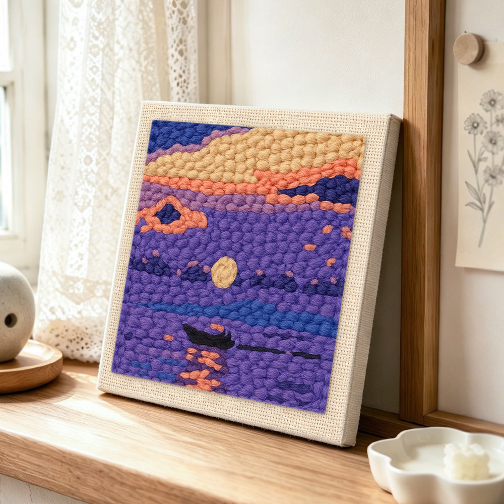 Purple lake and little boat punch needle artwork displayed on a table
