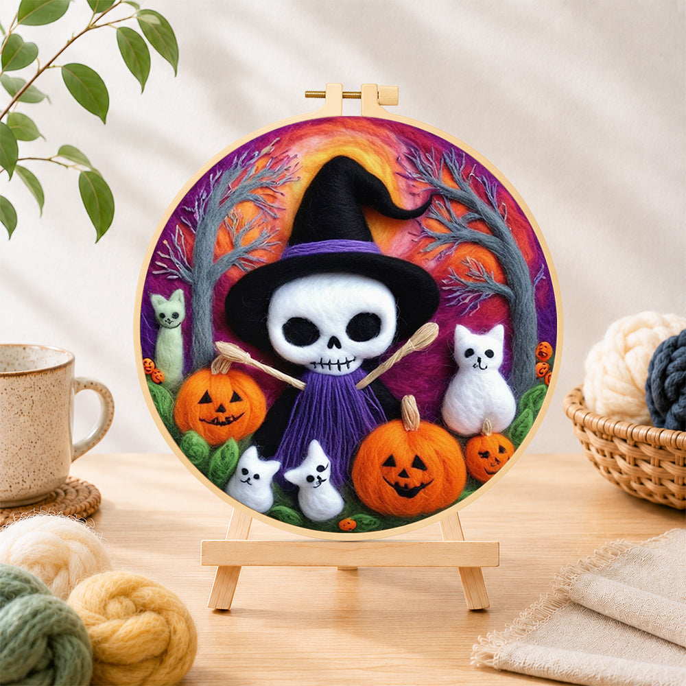 Finished purple skull witch with broom needle felting displayed on a wooden easel